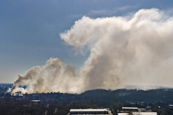 A plume of smoke from the Winston Weaver Co. fertilizer plant fire drifts west on Tuesday in Winston-Salem, N.C. The uncontrolled fire at the fertilizer plant has forced thousands of people to evacuate the area around the plant.