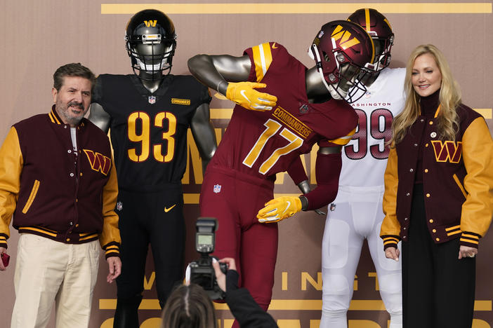 Dan, left, and Tanya Snyder, co-owner and co-CEOs of the Washington Commanders, pose for photos after unveiling their NFL football team's new identity, on Wednesday. The new name comes 18 months after the once-storied franchise dropped its old moniker following decades of criticism that it was offensive to American Indians.