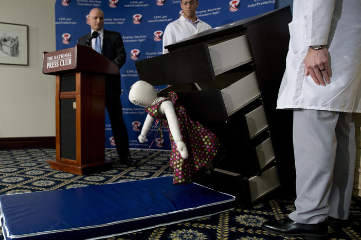 Elliot Kaye (left), then chairman of the Consumer Product Safety Commission, watches a demonstration of how an Ikea dresser can tip and fall on a child during a news conference at the National Press Club in 2016.