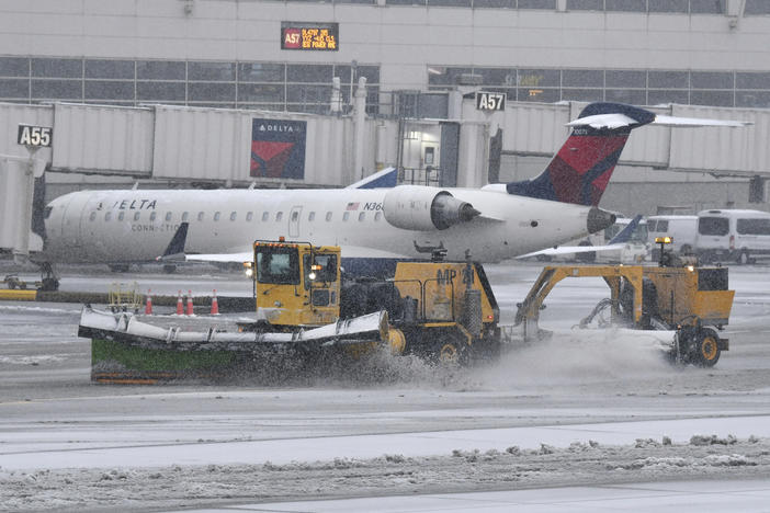 A plow clears away snow at Detroit Metropolitan Wayne County Airport in Romulus, Mich., on Wednesday.