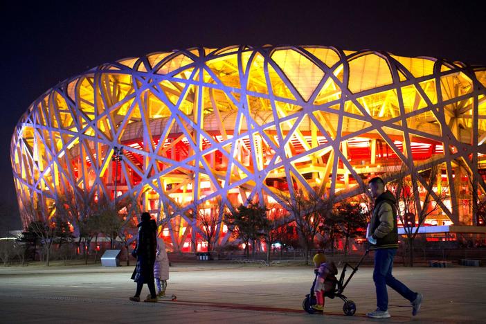 People walk past the Birds Nest stadium in Beijing on Feb. 4, 2021. Exactly a year later, it is hosting the opening ceremony for the 2022 Winter Olympics.
