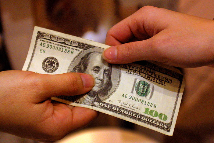 A shopper pays with cash back in 2000 in Austin, Texas. Such transactions are less and less common and are likely to become more so if the Federal Reserve adopts a digital version of the dollar.