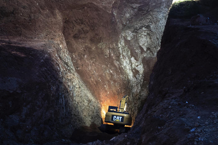 Heavy equipment is used to dig through a mountain on Friday during an attempt to rescue a boy trapped in a well.