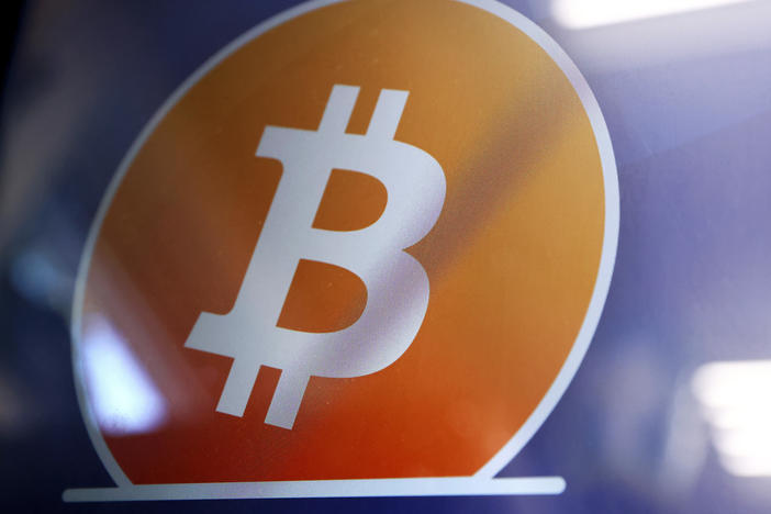 The Bitcoin logo is displayed on the screen of a Bitcoin ATM in Los Angeles. The Justice Department said a New York couple has been charged with conspiring to launder billions of dollars' worth of stolen bitcoin.