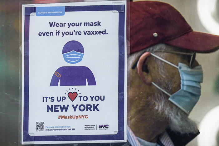 A sign reminds customers that masks are required in their store in New York in December. A growing number of states are lifting their indoor mask mandates in the coming weeks.