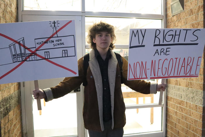 Huntington High School senior Max Nibert holds signs he planned to use during a walkout students were to stage at Huntington High School in Huntington, W. Va., on Wednesday. The protest followed an evangelistic Christian revival assembly last week that some students at Huntington High were mandated by teachers to attend.