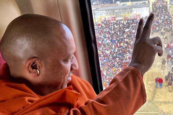 Uttar Pradesh Chief Minister Yogi Adityanath flashes a victory sign to the crowd from a helicopter as he leaves after an election rally ahead of state elections in Muradabad, India, Tuesday, Feb.8, 2022.