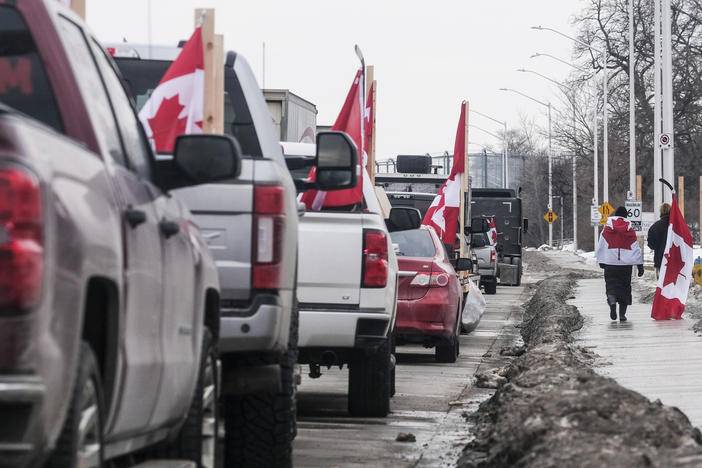 Protesters with trucks and other vehicles adorned in signs and Canadian flags gather near Ambassador Bridge on February 9 in Windsor, Canada. The bridge is the busiest land border crossing in North America in terms of trade volume.