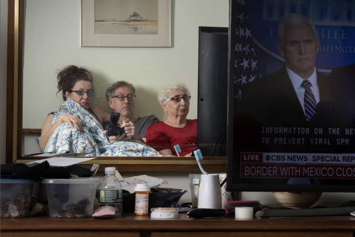 Sophia Lansky, Neil Kramer and Kramer's mother, Elaine, watch the news in March 2020, from their two-bedroom apartment in Queens.