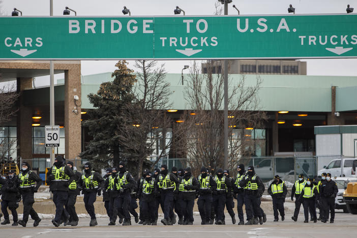 Police arrive to clear protesters and their vehicles from a blockade at the entrance to the Ambassador Bridge in Windsor, Ontario on Saturday.