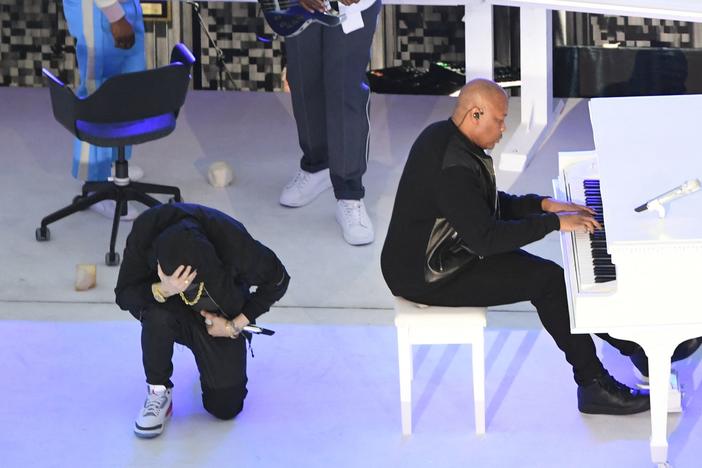 Eminem took a knee as he performs during the Super Bowl halftime show.