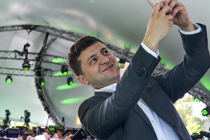 Ukrainian President Volodymyr Zelenskyy takes a selfie at the first congress of his party called Servant of the People in the city Botanical Garden, Kiev, Ukraine, Sunday, June 9, 2019.