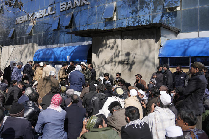 Afghan wait to enter a bank, in Kabul, Afghanistan, Sunday, Feb. 13, 2022.