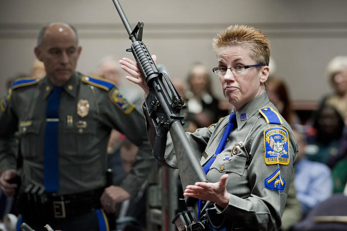 Firearms training unit Detective Barbara Mattson, of the Connecticut State Police, holds up a Bushmaster AR-15 rifle — the same make and model of the gun used in the Sandy Hook School shooting.