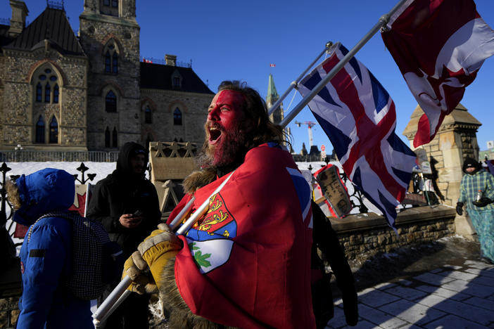 A protester yells "freedom" towards a person who attempted to stick a paper sign on a truck criticizing the Freedom Convoy protest against COVID-19 measures on Monday.