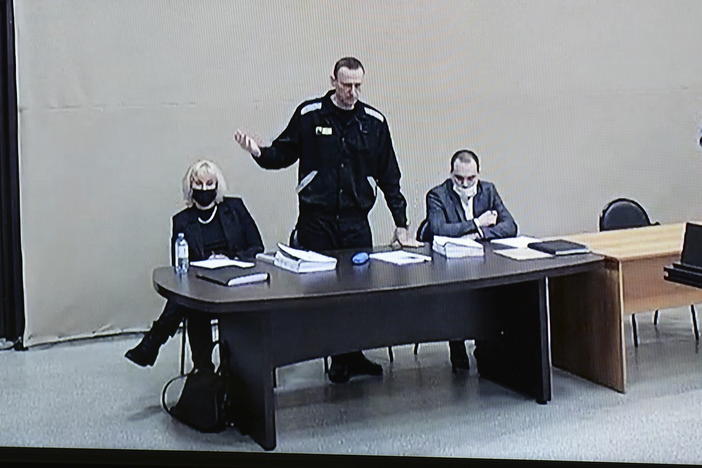 In this image provided by the Russian Federal Penitentiary Service, Russian opposition leader Alexei Navalny speaks via a video link, as he stands next to his lawyers during a court session in Pokrov, Vladimir region, about 62 miles east of Moscow, Russia, in January.