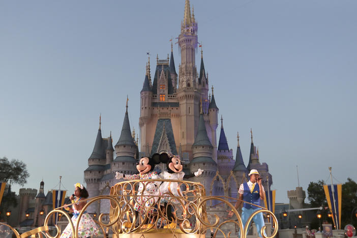 Mickey and Minnie Mouse perform during a parade as they pass by the Cinderella Castle at the Magic Kingdom theme park at Walt Disney World in Florida. The theme park resort announced Tuesday that face coverings will be optional for fully vaccinated visitors in all indoor and outdoor locations.