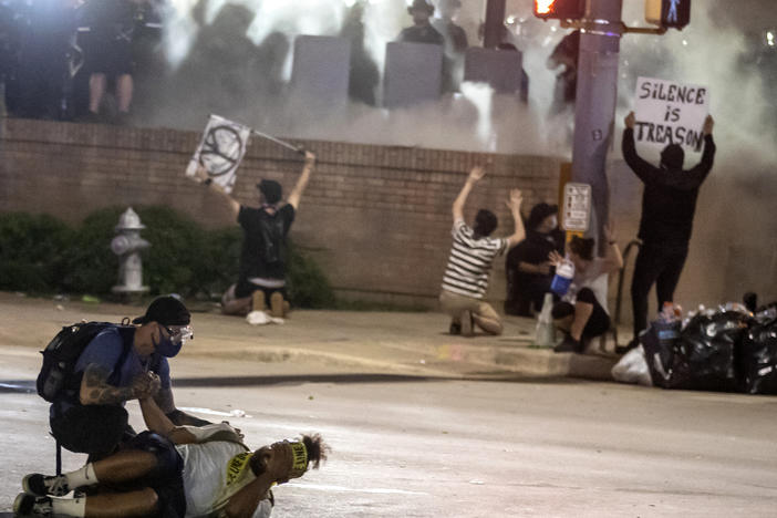 People help a protester after he was shot with a rubber bullet in Austin, Texas, in May 2020 while protesting the death of George Floyd. The Austin City Council on Thursday approved paying a combined $10 million to two people injured when officers fired beanbag rounds into crowds during the protests, including a college student who suffered brain damage.