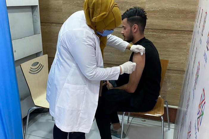 Hussein Raad, a 22-year-old college student, gets his second dose of the Pfizer vaccine at Zayoona Mall in Baghdad.