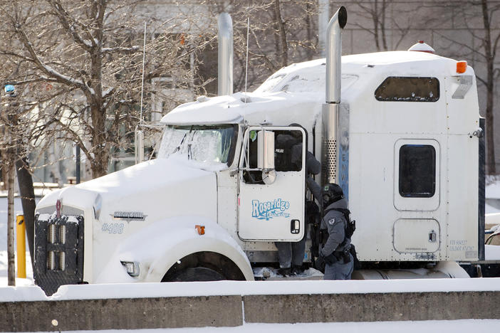 Police officers enter a blockade protest truck parked in downtown Ottawa on Friday as they began arresting protesters.