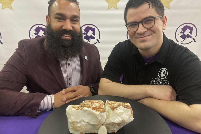 Dan Newman, left, the founder of Alaska Premier Auctions and Appraisals, and Nick Cline, a business partner, pose Friday in Anchorage with the "Americus Australis," thought to be one the largest gem-quality opals in existence.
