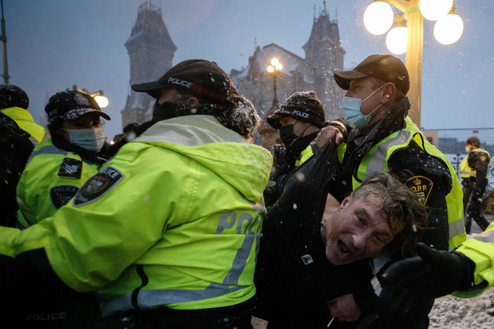 A man is arrested by police in Ottawa on Thursday as demonstrators and supporters gather in a protest against COVID-19 measures that has grown into a broader anti-government protest.