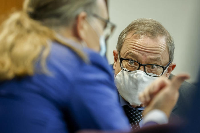 Greg McMichael, center, listens to his attorney during his 2021 state murder trial. McMichael, his son Travis McMichael, and neighbor William "Roddie" Bryan are now on trial for committing federal hate crimes against Ahmaud Arbery.