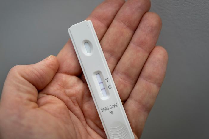 A rapid antigen test shows a positive test result for COVID-19.