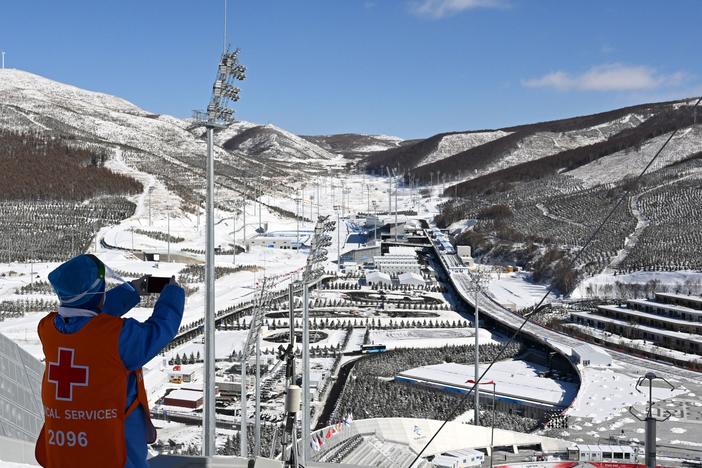 A medical helper takes a photo of the Zhangjiakou National Ski Jumping Center during the Winter Olympics on Feb. 14.