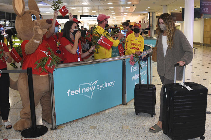 Passengers are welcomed as they arrive at Sydney International Airport in Sydney on Monday.