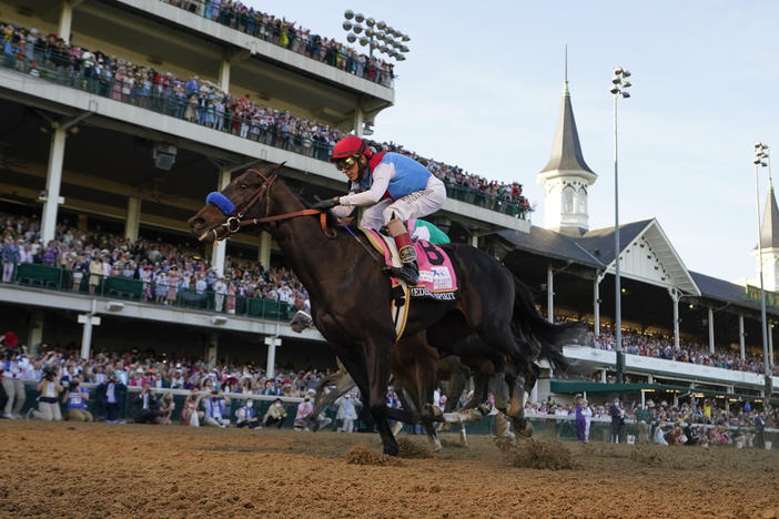 John Velazquez rides Medina Spirit across the finish line at the Kentucky Derby at Churchill Downs in Louisville, Ky., in May 2021. Medina Spirit failed a post race drug test and on Monday, was stripped of his 2021 title.