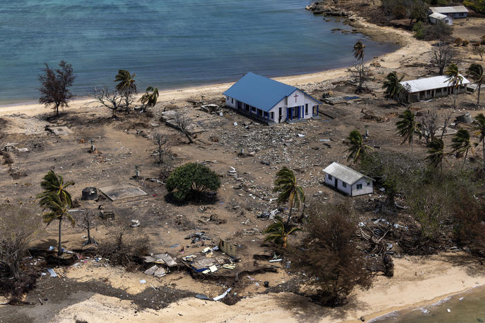 In this photo provided by the Australian Defence Force, debris from damaged building and trees are strewn around on Atata Island in Tonga, on Jan. 28, 2022, following the eruption of an underwater volcano and subsequent tsunami.