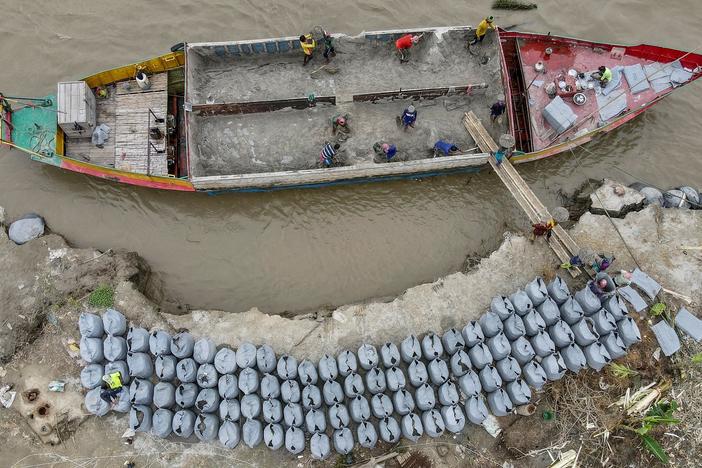 Workers place geo-textile bags to prevent river erosion on the banks of Padma River in Bangladesh last September.