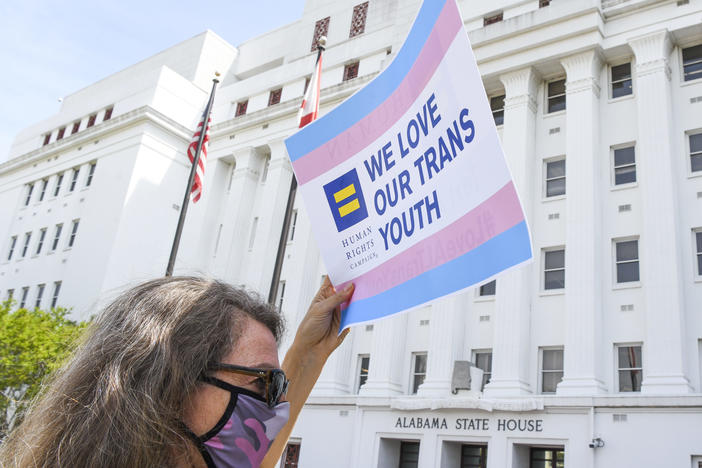 Jodi Womack holds a sign that reads "We Love Our Trans Youth" during a rally at the Alabama State House to draw attention to anti-transgender legislation introduced in Alabama on March 30, 2021 in Montgomery, Ala.