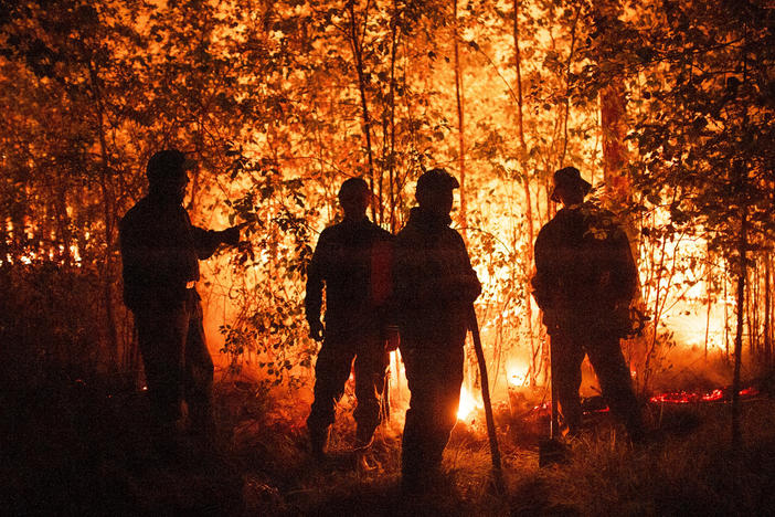 Firefighters work at the scene of forest fire near Kyuyorelyakh village west of Yakutsk, in Russia on Aug. 5, 2021.