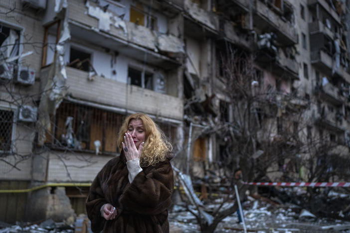 Natali Sevriukova reacts next to her house following a rocket attack the city of Kyiv, Ukraine, Friday, Feb. 25, 2022.