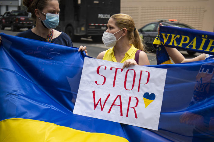 Ukrainian citizens hold posters and national flags during a demonstration in support of Ukraine outside the Russian Embassy in Lima, Peru, on Friday.