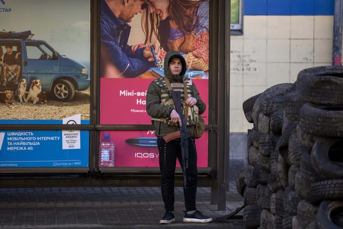 A civil defense guard stands at a checkpoint in Kyiv, Ukraine, on Saturday. Russian troops stormed toward Ukraine's capital, and street fighting broke out as city officials urged residents to take shelter.