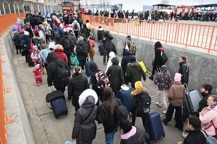 People coming from Ukraine descend from a ferry boat to enter Romania at the Isaccea-Orlivka border crossing at the Danube river.