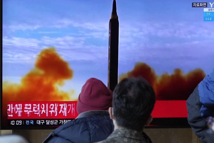 People at the Seoul Railway station watch a TV showing a file image of North Korea's missile launch during a news program on Sunday, Feb. 27, 2022.