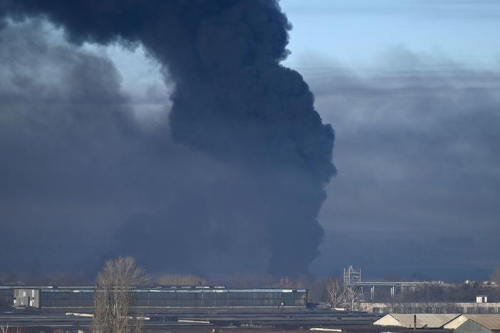 Black smoke rises from a military airport in Chuhuiv, near Kharkiv, Ukraine, on Thursday. Humanitarian organizations say Russian forces are using cluster munitions in their bombing and shelling of Ukraine.