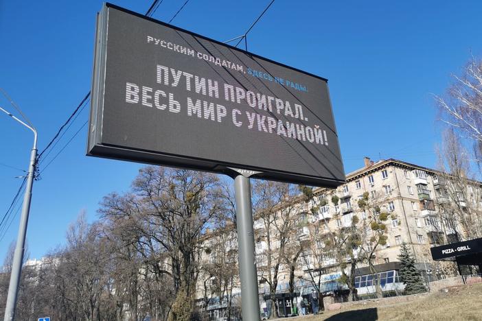 An electronic billboard along Kyiv's Victory Avenue, the route Russian tanks are expected to take, shows a message to Russian soldiers reading "Putin lost, the entire world is with Ukraine," on  Monday.