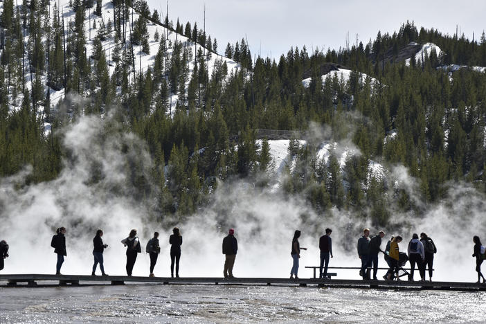 Visitors are seen at Grand Prismatic Spring in Yellowstone National Park, Wyo., last year.