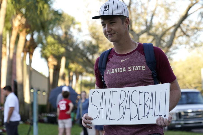 A baseball fan stands outside Roger Dean Stadium as Major League Baseball negotiations continued earlier this week in Jupiter, Fla.