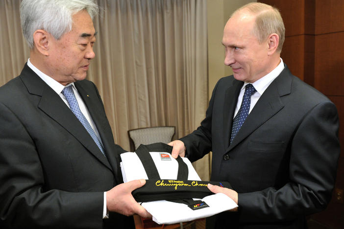 World Taekwondo Federation President Choue Chung-won, left, gives an honorary taekwondo black belt and uniform to Russian President Vladimir Putin in 2013.