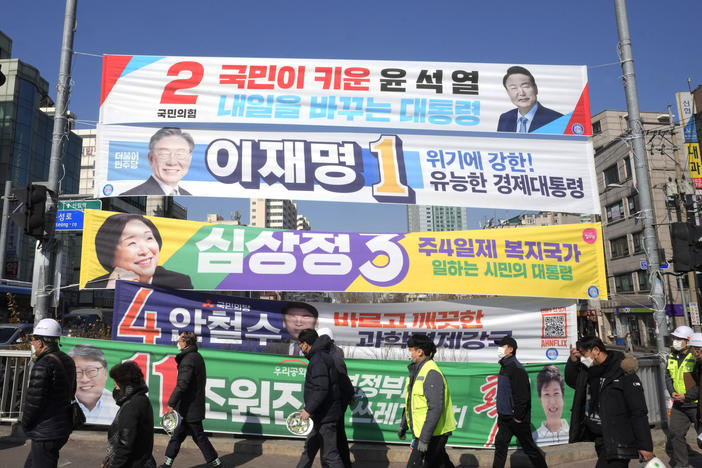 Placards featuring ruling and opposition presidential candidates hang over a street in Seoul, South Korea, on Feb. 17, 2022.