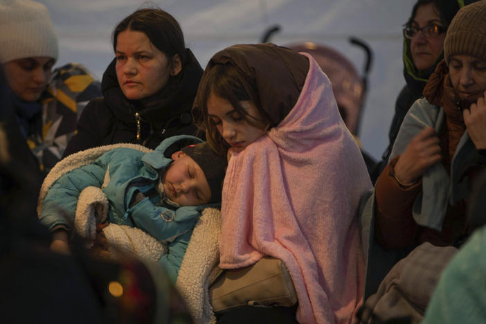 Refugees, mostly women with children, rest inside a tent after arriving at the border crossing, in Medyka, Poland on Sunday.