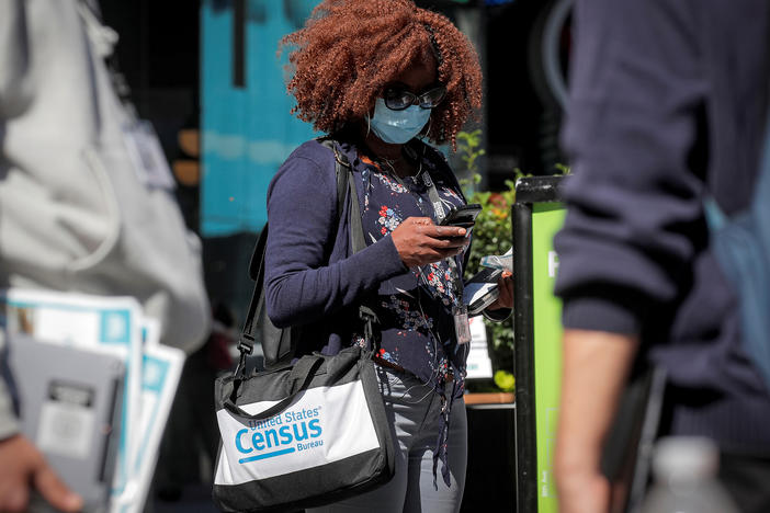 A Census Bureau worker waits to gather information from people during a 2020 census promotional event in New York City.