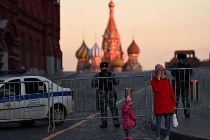 A woman makes a phone call in front of police officers blocking access to Red Square in central Moscow on March 2, 2022