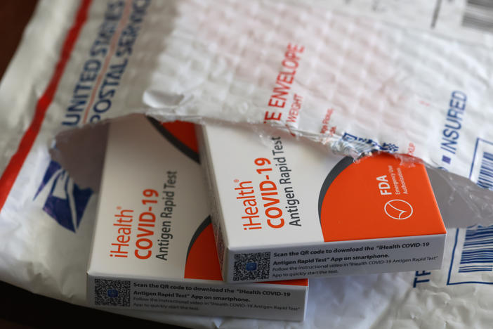 In this photo illustration, free iHealth coronavirus rapid tests from the federal government sit in a U.S. Postal Service envelope after being delivered on Feb. 4.